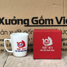 Cốc sứ in logo TCD K11 Học Viện Ngân Hàng dáng Vát có quai màu trắng XG-LS145