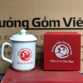 Cốc sứ in logo Trường Mầm Non Hoàng Anh dáng trụ cao có nắp màu trắng XG-LS147