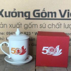 Cốc sứ in logo Kỷ Niệm 50 Năm Ngày Truyền Thông Bệnh Viện Quân Y 78 dáng ngọn lửa có nắp kèm dĩa lót XG-LS136