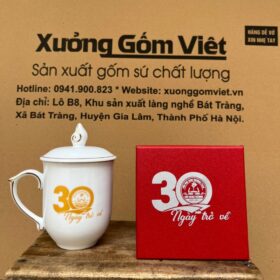 Cốc sứ Bát Tràng in logo 30 năm kỷ niệm ngày trở về trường cấp II Võ Như Hưng dáng ngọn lửa có nắp màu trắng viền kim XG-LS196