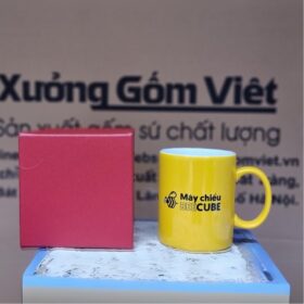 Cốc sứ Bát Tràng in logo máy chiếu Beecube dáng trụ quai chữ C màu vàng XG-LS200