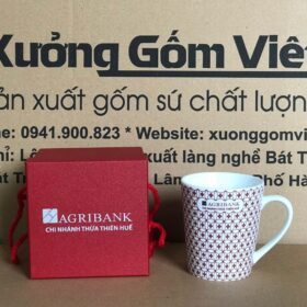 Cốc sứ trắng Bát Tràng in logo Agribank chi nhánh Thừa Thiên Huế dáng vát thấp họa tiết hoa đỏ in quanh cốc XG-LS198