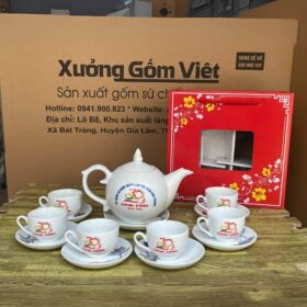 Bộ ấm chén Bát Tràng in logo kỷ niệm thành lập màu trắng bưởi nắp chóp lửa họa tiết hoa sen xanh viền kim XG-AC110